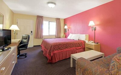 Day room with work desk and couch at Days Inn By Wyndham East Albuquerque.