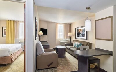 Day room at Candlewood Suites Times Square, with workspace, couch and large window.