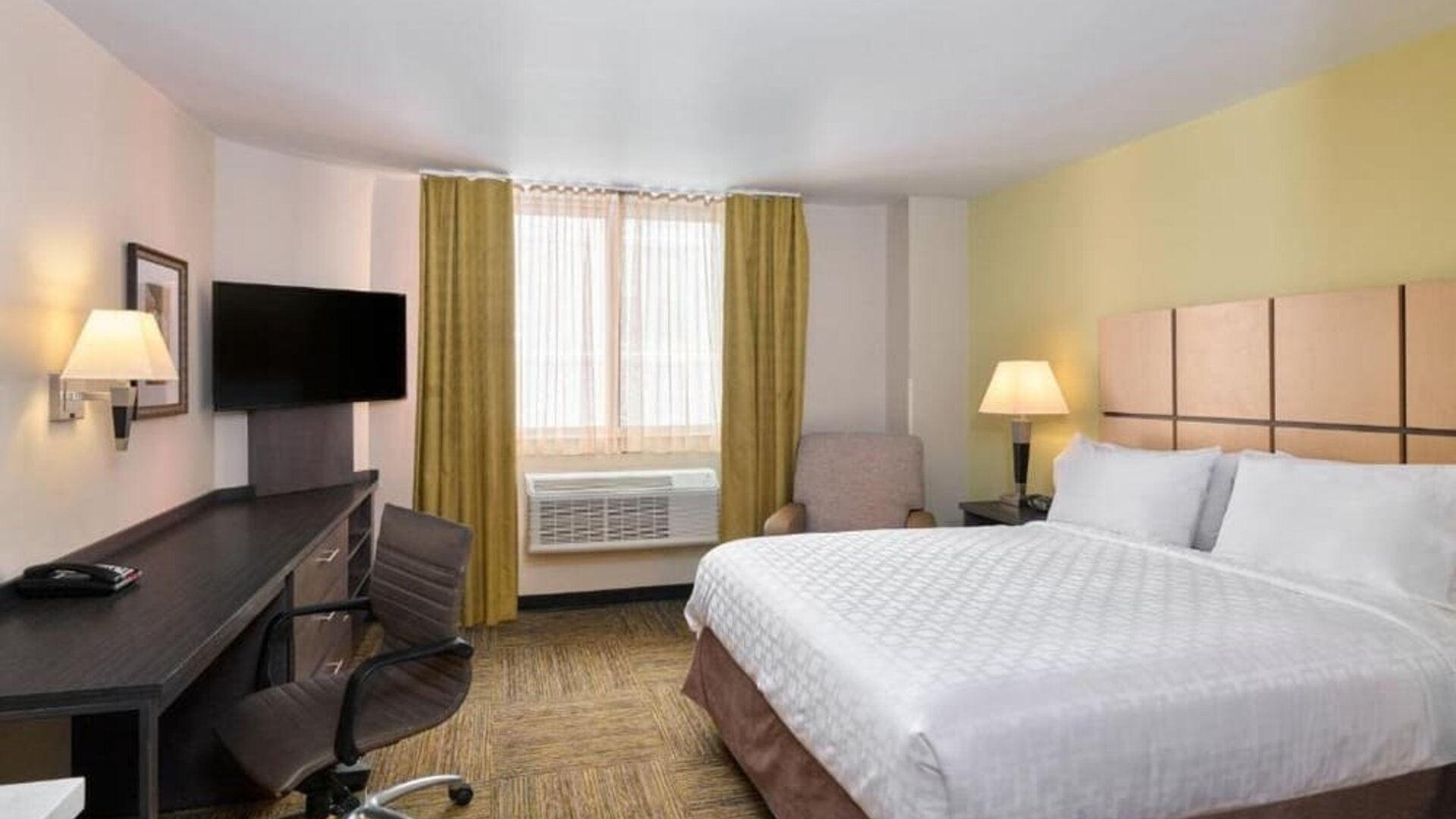 Day room at the Candlewood Suites Times Square, with workspace nearby and large window.