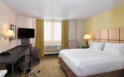 Day room at the Candlewood Suites Times Square, with workspace nearby and large window.