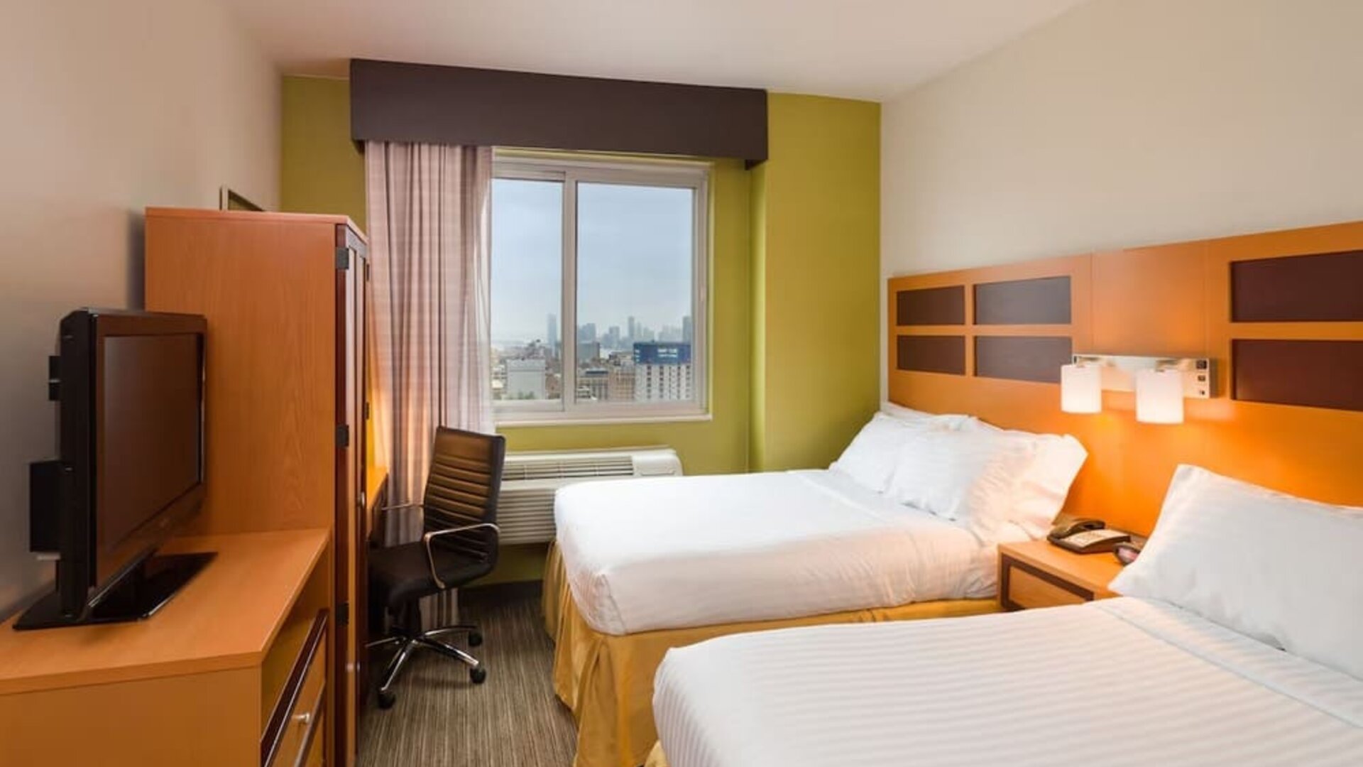 Day room at the Holiday Inn Express Times Square’s with workspace and a televison.