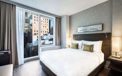 Day use room with large windows providing a beautiful view of the city at The Bernic Hotel New York City, Tapestry Collection By Hilton.