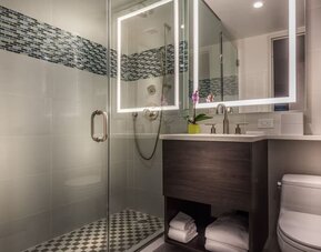 Beautiful, modern bathroom with plush towels at The Bernic Hotel New York City, Tapestry Collection By Hilton.