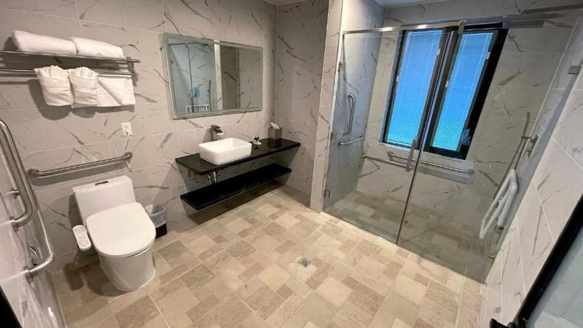 Modern bathroom with plush towels at Liberty View Brooklyn Hotel.