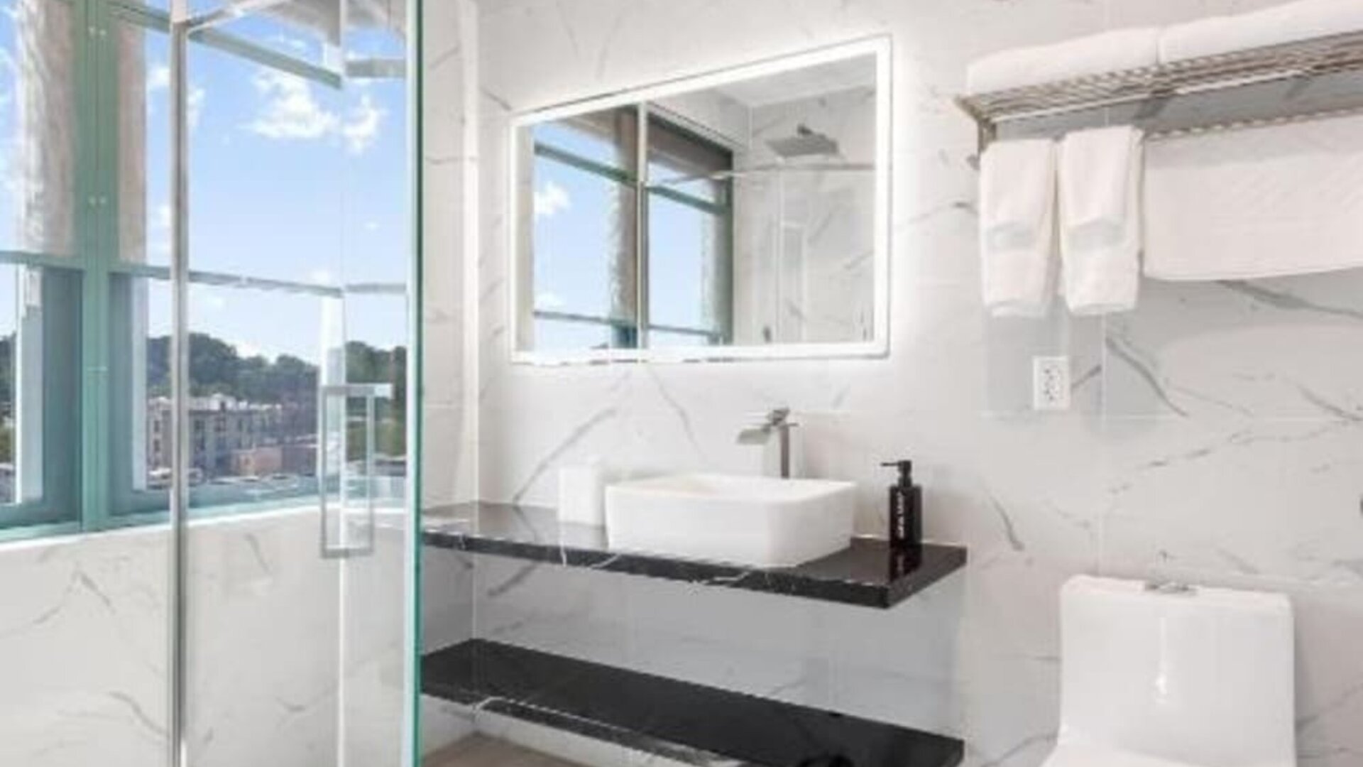 Modern bathroom with plush towels at Liberty View Brooklyn Hotel.