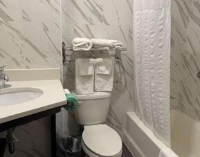 Bathroom with towels at Days Inn By Wyndham Brooklyn Marine Park.