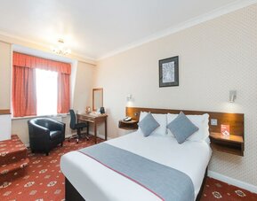 Day room with workspace and a couch at Stade Court Hotel.