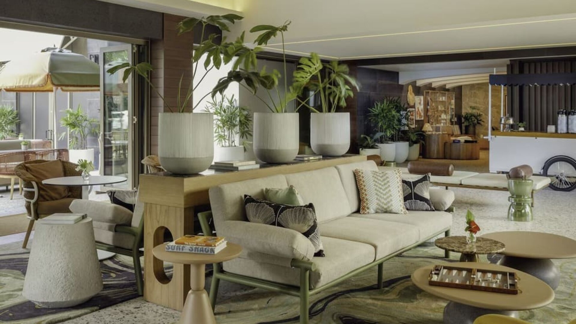 Lobby lounge with seating, indoor plants, and modern decor at The Ambassador Hotel Of Waikiki.