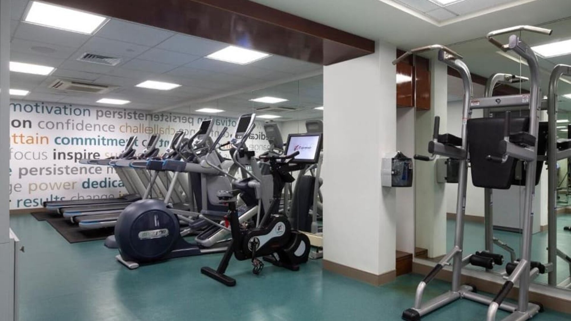 Fitness center with treadmills, elliptical machines, and mirrored walls at The Twin Fin Hotel.