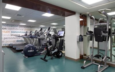 Fitness center with treadmills, elliptical machines, and mirrored walls at The Twin Fin Hotel.