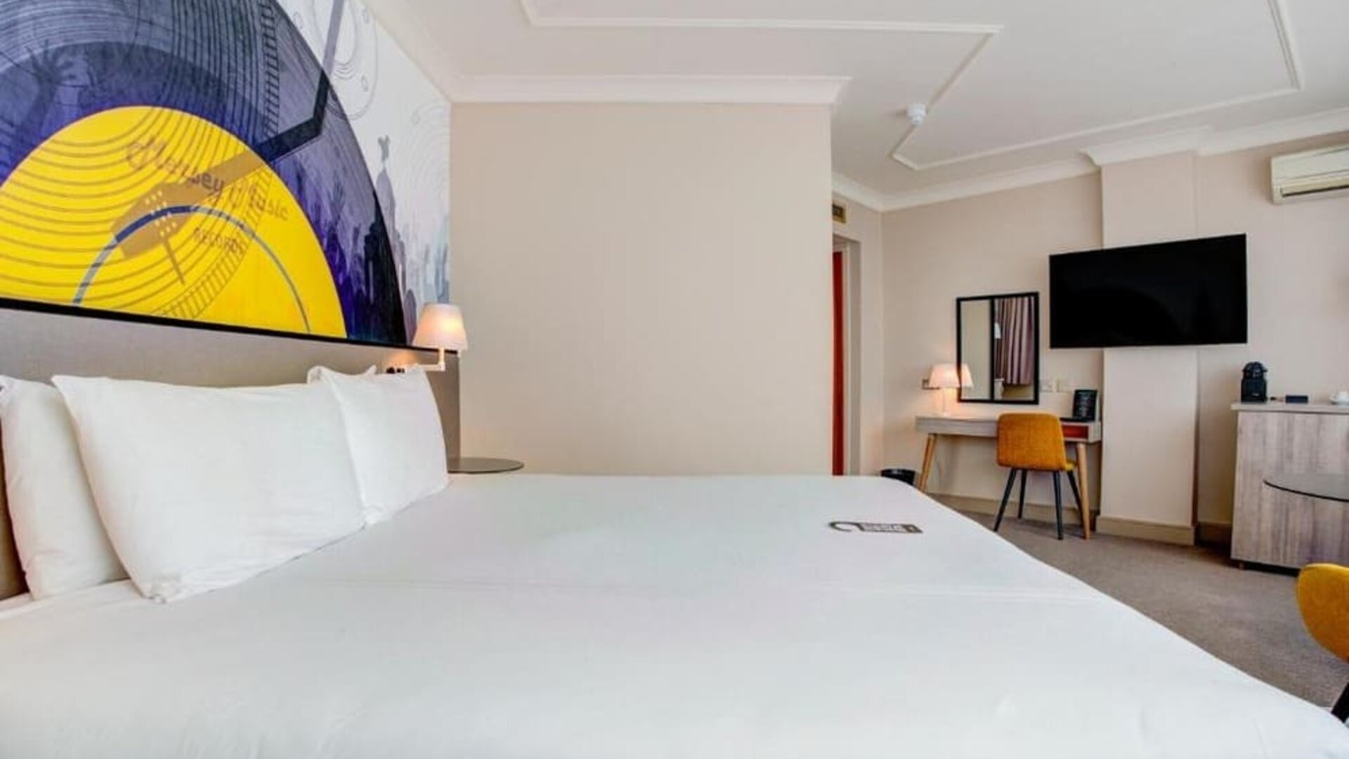 Comfortable double room with large bed, wall art, desk, and TV at Atlantic Tower Hotel Liverpool By Sunday.