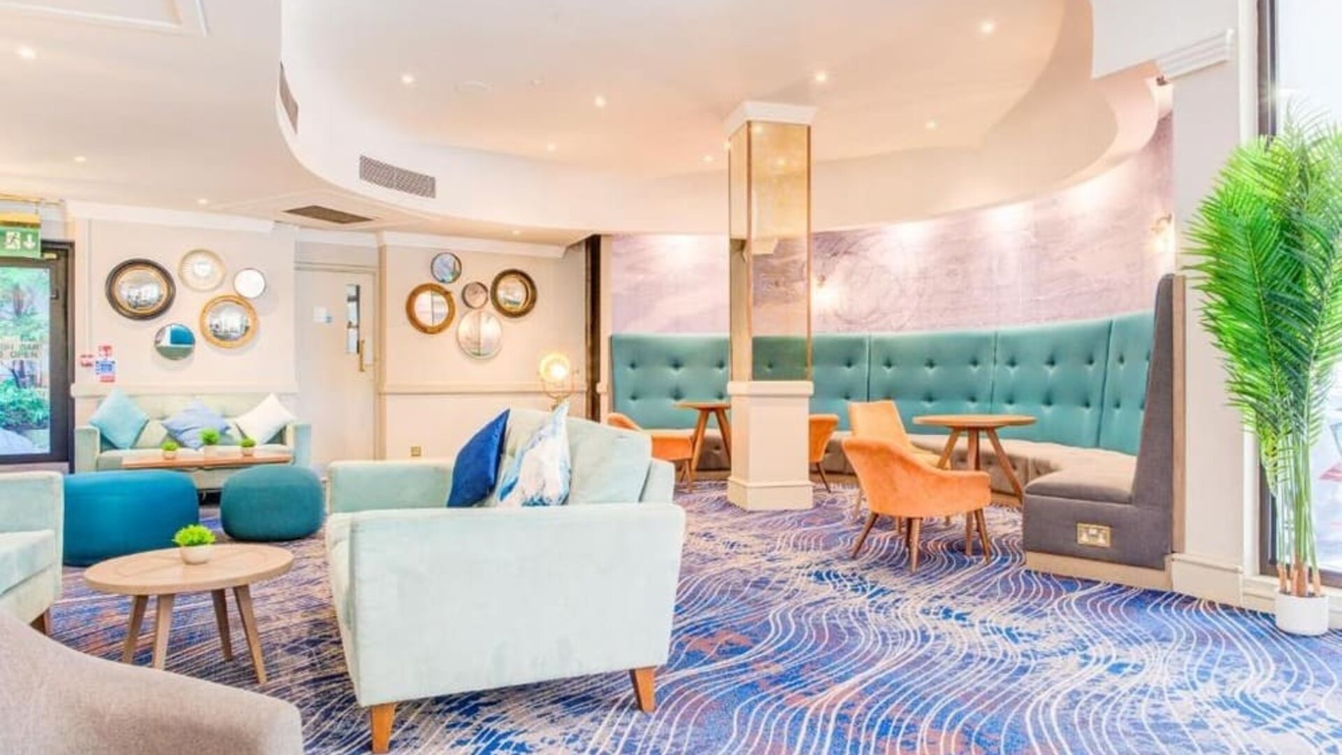 Cozy lounge area with sofas, armchairs, and decorative wall accents at Atlantic Tower Hotel Liverpool By Sunday.