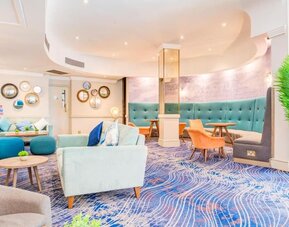 Cozy lounge area with sofas, armchairs, and decorative wall accents at Atlantic Tower Hotel Liverpool By Sunday.