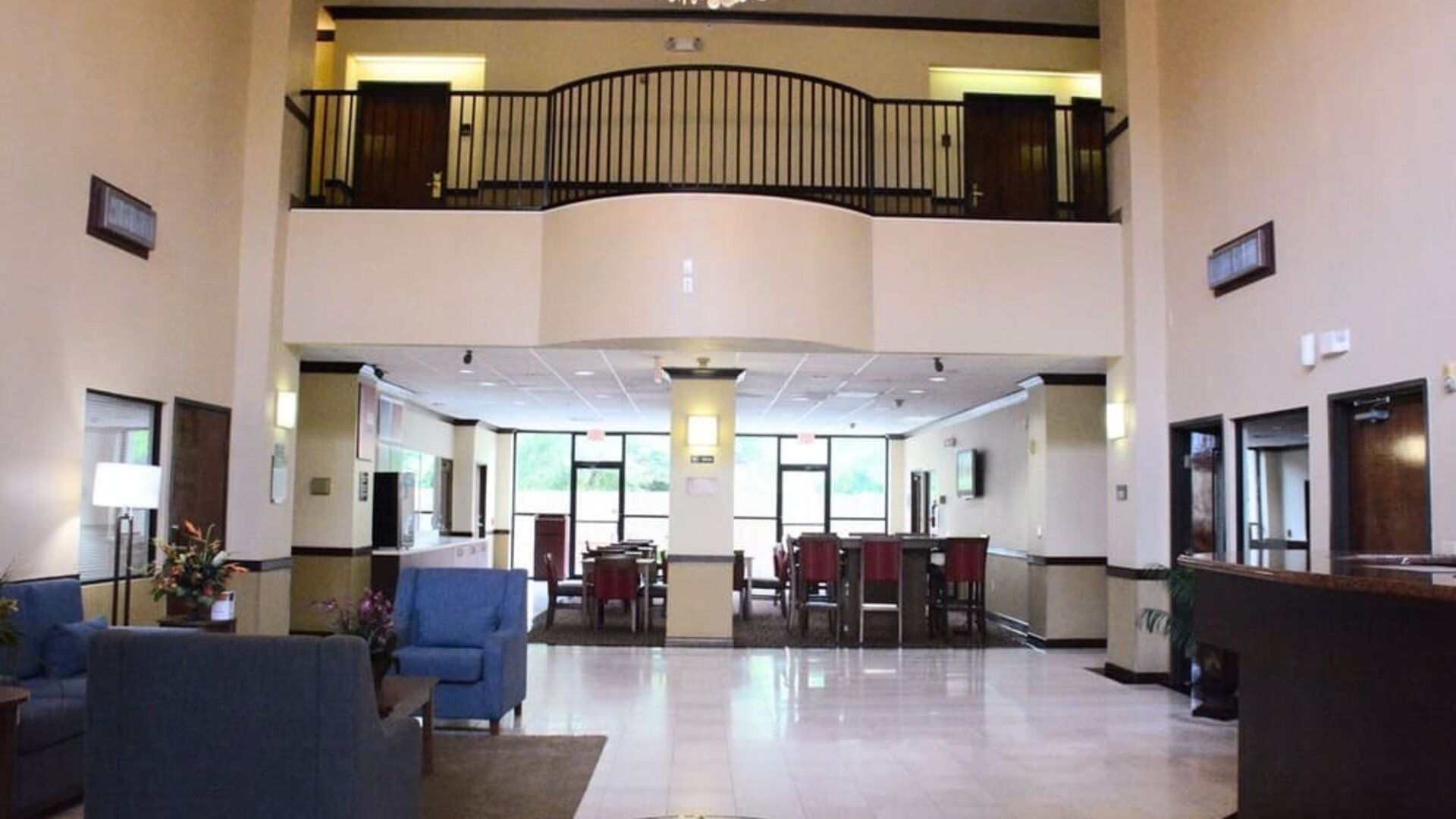 Lobby with high ceiling, chandelier, seating area, and reception desk in an open space at Comfort Suites Bush Intercontinental Airport.
