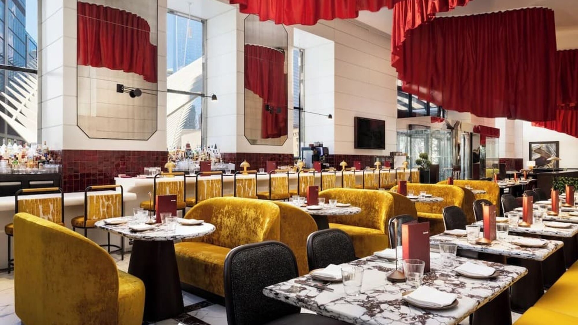 Dining area with booths, bar seating, red accents, and modern lighting design at M Social New York Downtown.