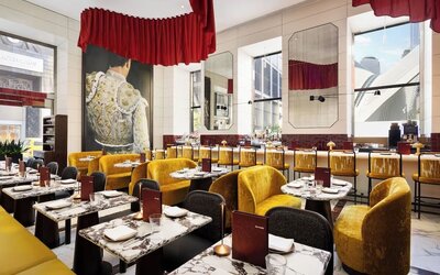 Restaurant dining area with marble tables, red accents, gold seating, and statement artwork at M Social New York Downtown.
