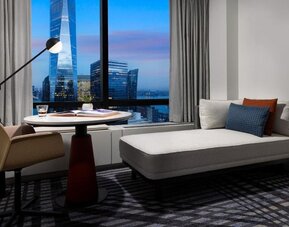 Lounge seating area with city skyline view at dusk through large windows at M Social New York Downtown.