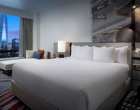 King room with plush bed, city skyline view, seating area, and modern décor at M Social New York Downtown.