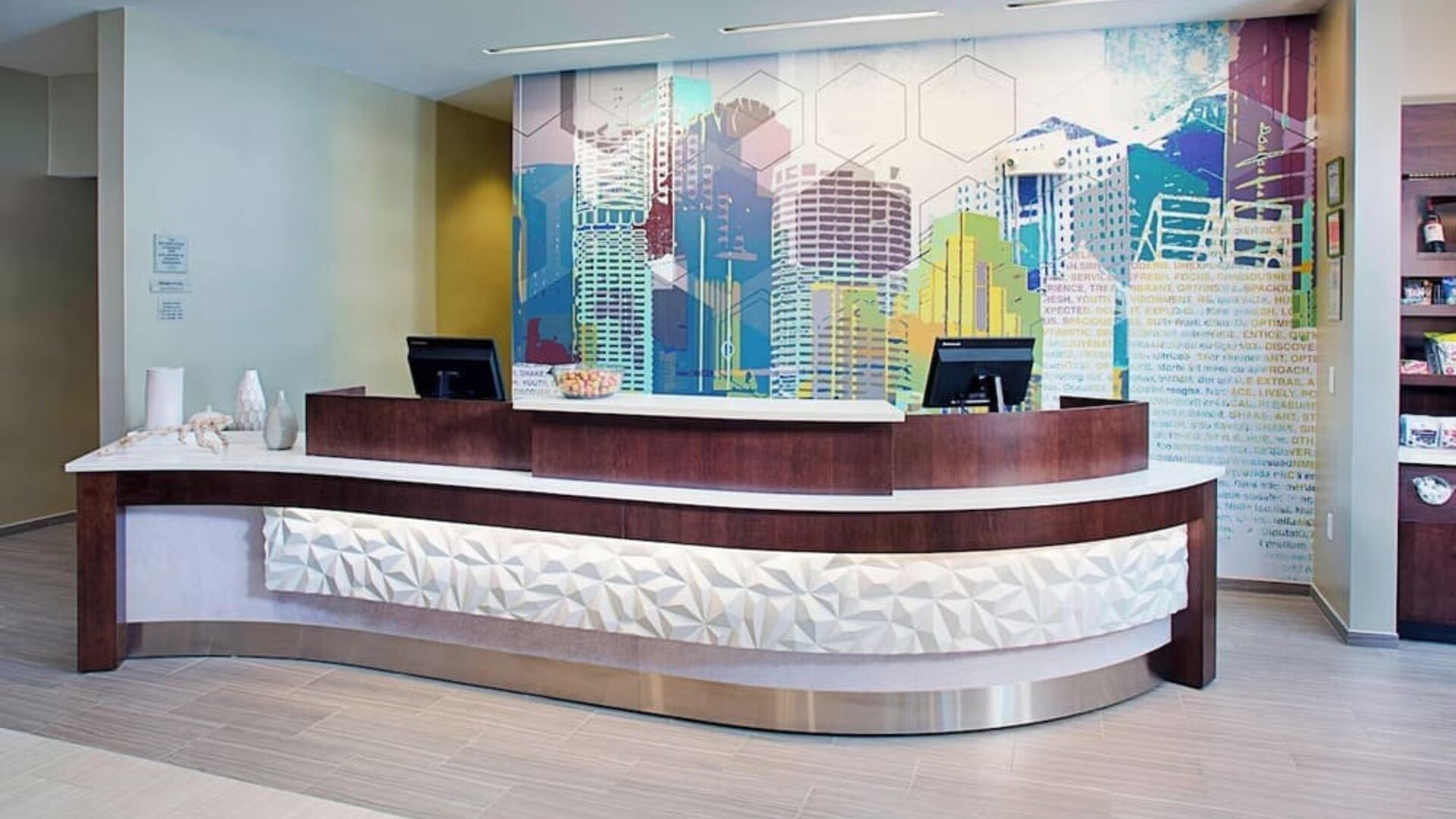 Reception desk area with modern design and colorful wall art at Springhill Suites Carle Place.