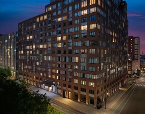 Exterior view of the hotel building at night with illuminated windows at Hilton Brooklyn New York.