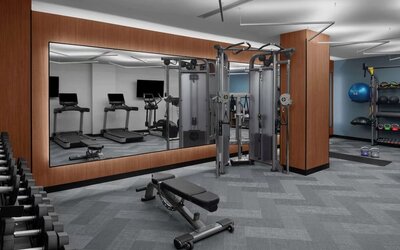 Fitness center with treadmills, weights, and strength training equipment at Hilton Brooklyn New York.