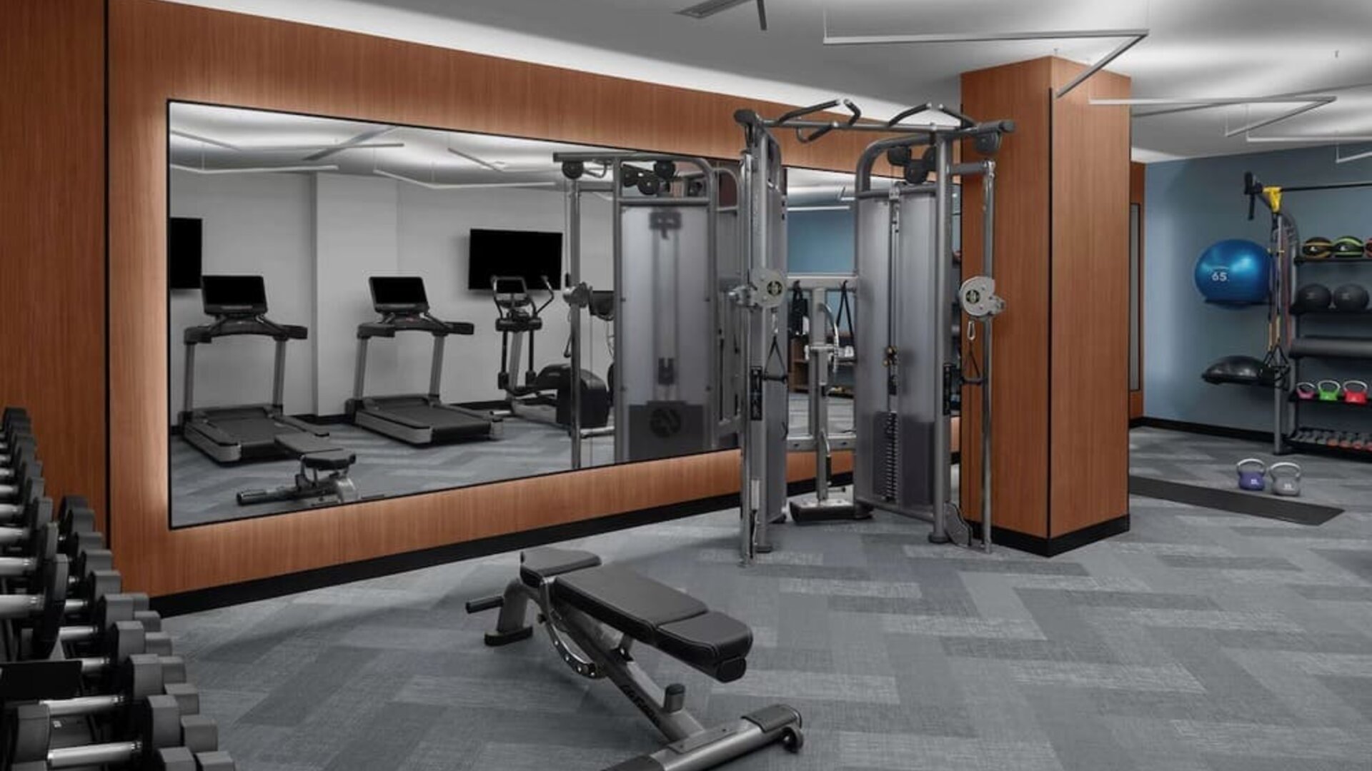 Fitness center with treadmills, weights, and strength training equipment at Hilton Brooklyn New York.