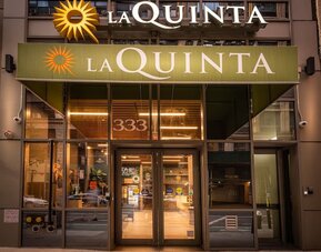 Hotel entrance with La Quinta signage and glass doors at La Quinta Times Square South.