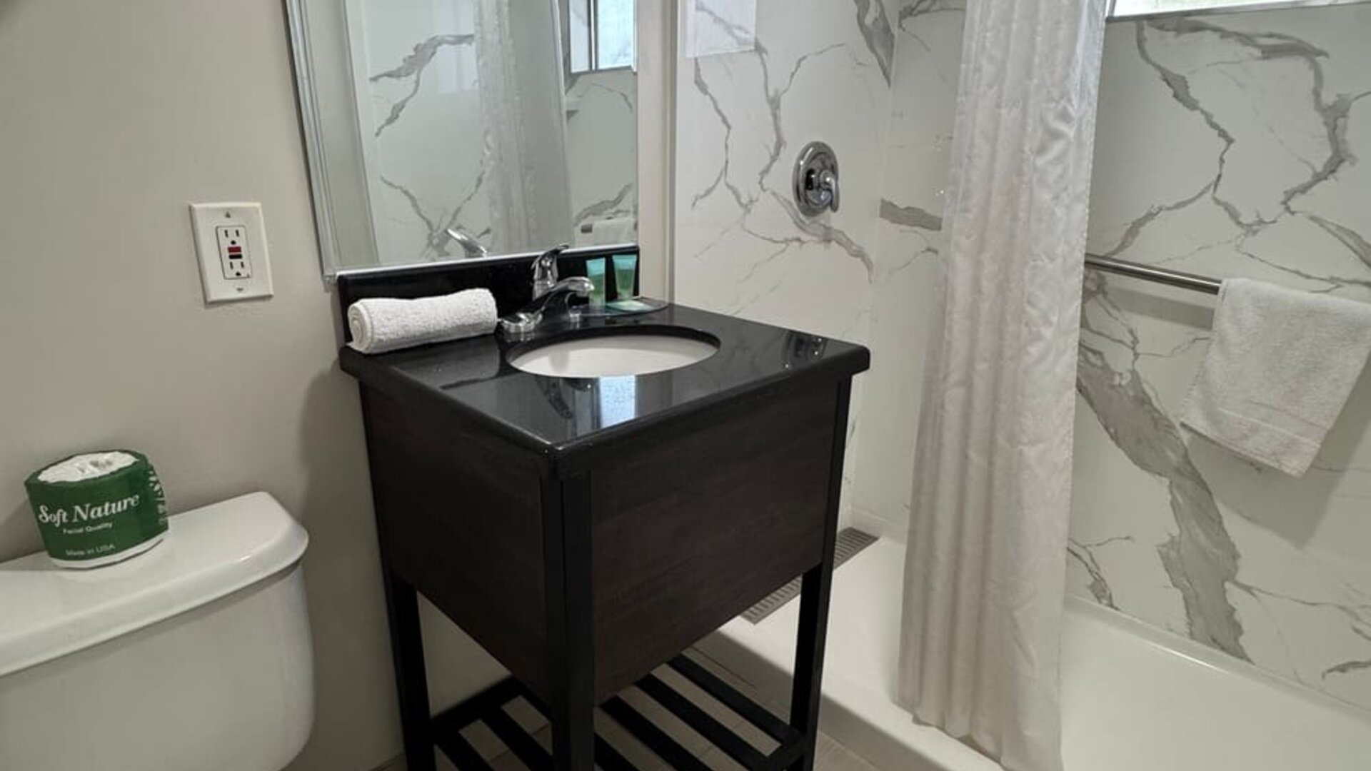 Guest bathroom with shower and toilet at Economy Inn.