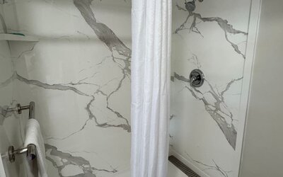 Guest bathroom with shower and toilet at Economy Inn.