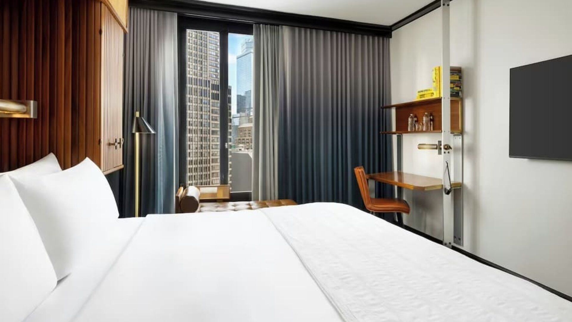 Guest room with king bed, workspace desk, and city view window at Le Méridien New York, Central Park.