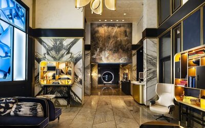 Hotel lobby with high ceilings, marble walls, seating area, and modern décor at Le Méridien New York, Central Park.