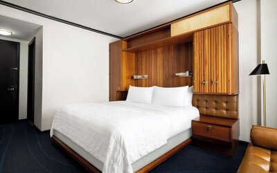 Guest room with king bed, modern décor, and workspace area at Le Méridien New York, Central Park.