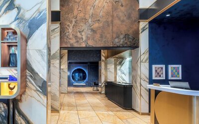 Lobby area with marble finishes, artwork, and reception desk at Le Méridien New York, Central Park.