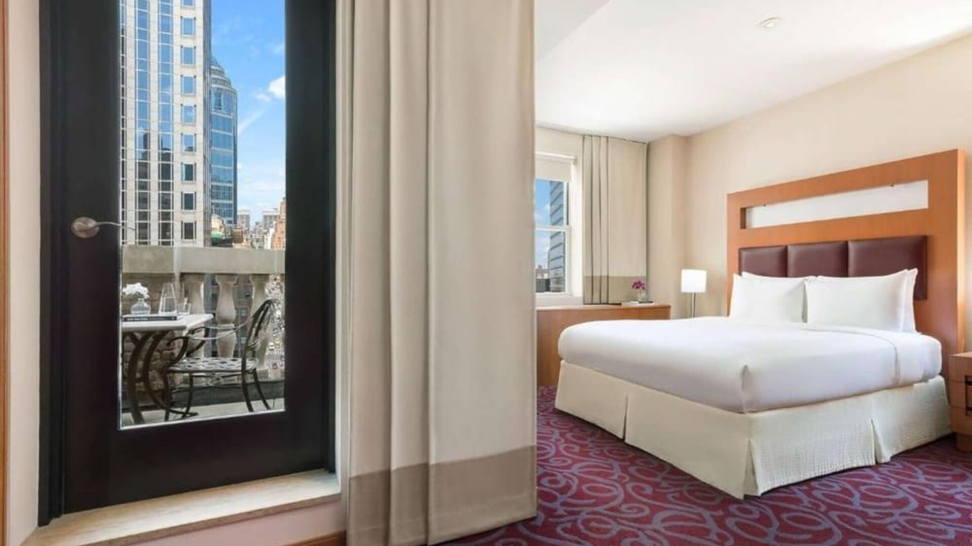Guest room with balcony access and king bed at Hotel 57.