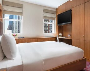 Guest room with king bed, workspace, and city views at Hotel 57.