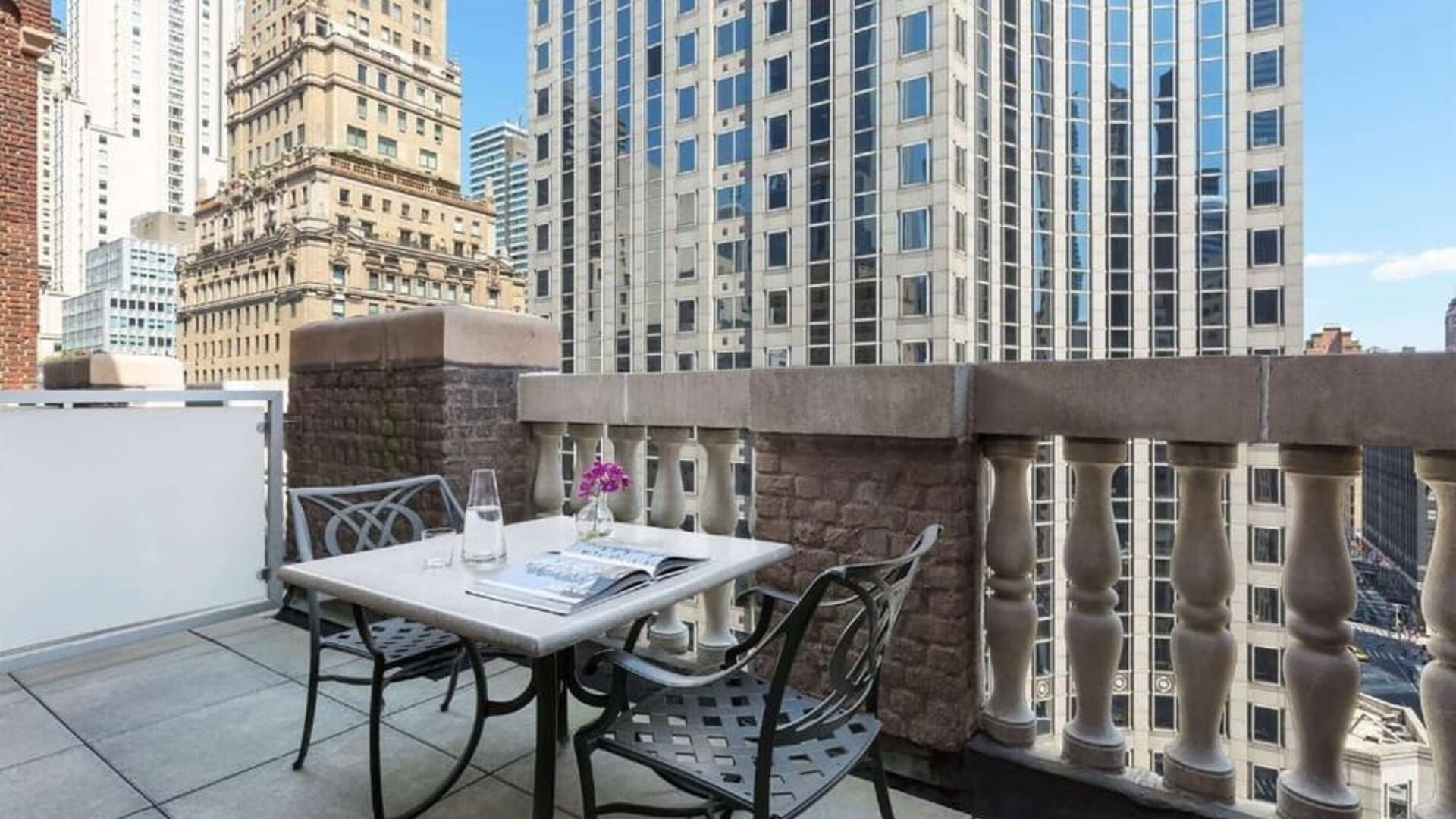 Private balcony with outdoor seating and city views at Hotel 57.