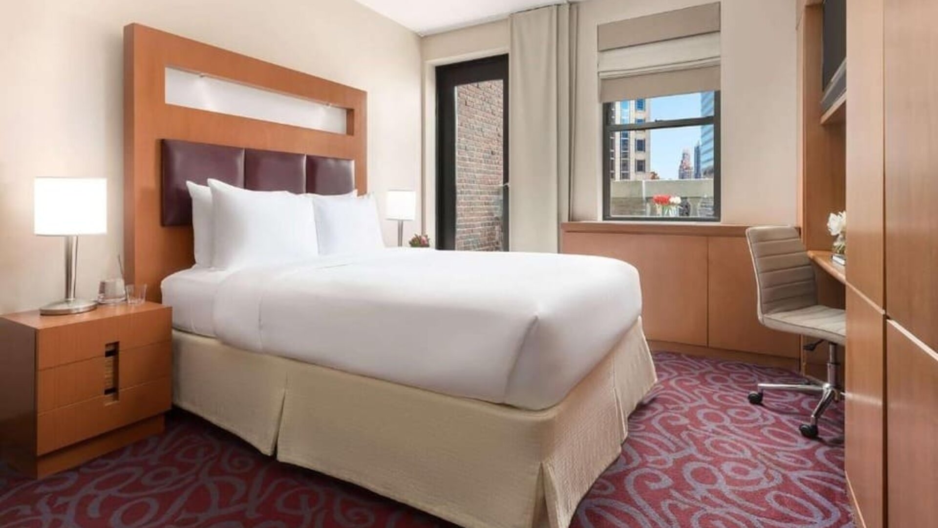 Guest room with king bed, workspace, and balcony access at Hotel 57.
