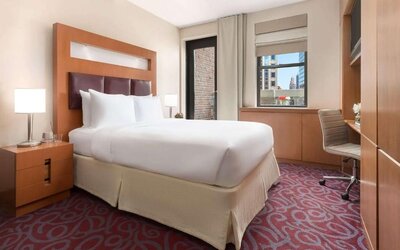 Guest room with king bed, workspace, and balcony access at Hotel 57.