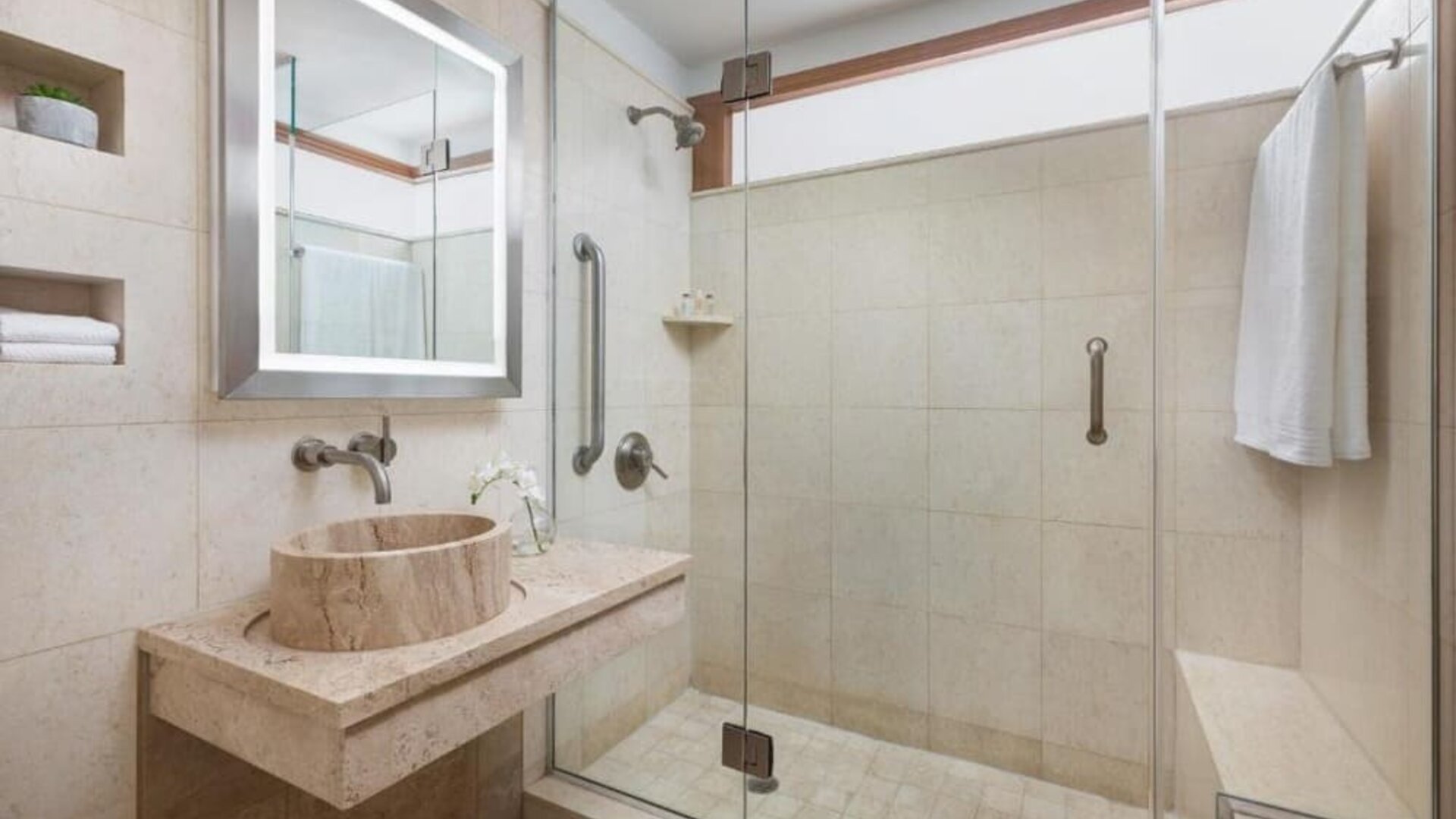 Bathroom with walk-in shower and modern stone finishes at Hotel 57.