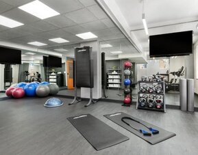 Fitness center with mats, weights, and training equipment at Hotel 57.