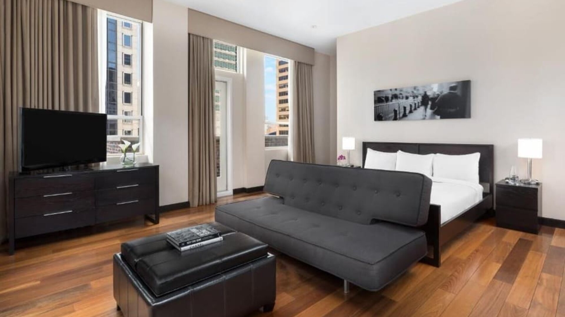 Spacious suite with living area, sofa, and city views at Hotel 57.