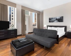 Spacious suite with living area, sofa, and city views at Hotel 57.