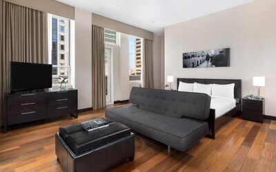 Spacious suite with living area, sofa, and city views at Hotel 57.