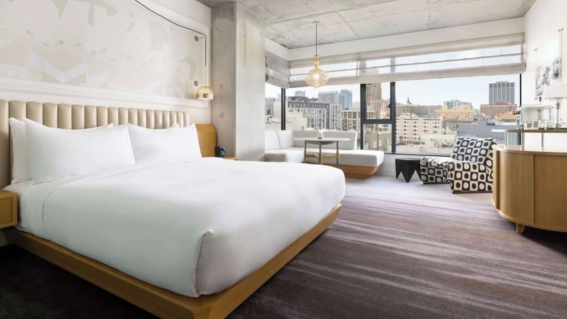 Spacious king room with large bed, modern décor, and city skyline views at Timbri Hotel San Francisco, Curio Collection By Hilton.