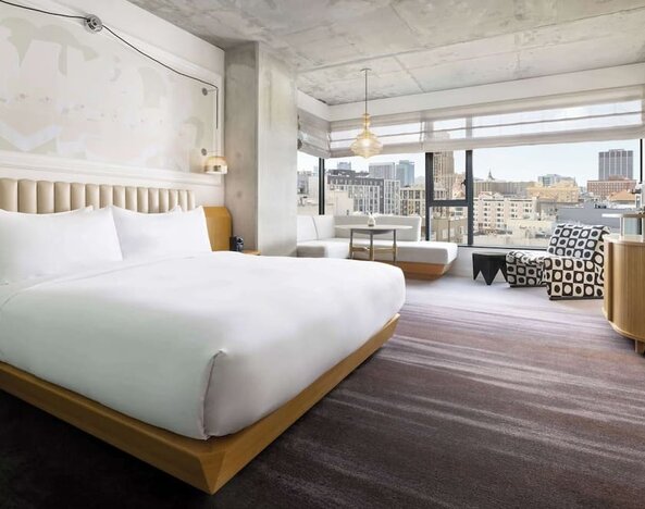 Spacious king room with large bed, modern décor, and city skyline views at Timbri Hotel San Francisco, Curio Collection By Hilton.