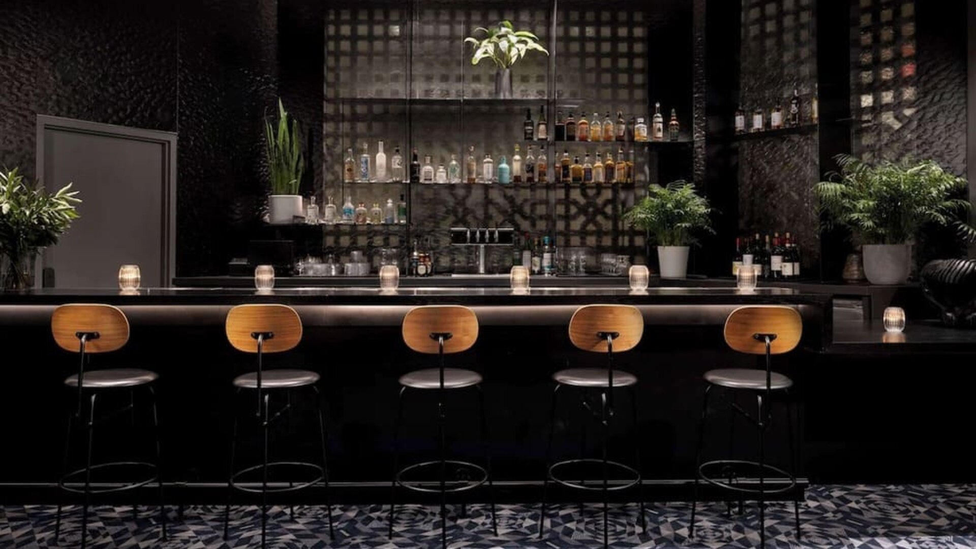 Elegant bar area with high stools, ambient lighting, and a curated selection of drinks at Timbri Hotel San Francisco, Curio Collection By Hilton.