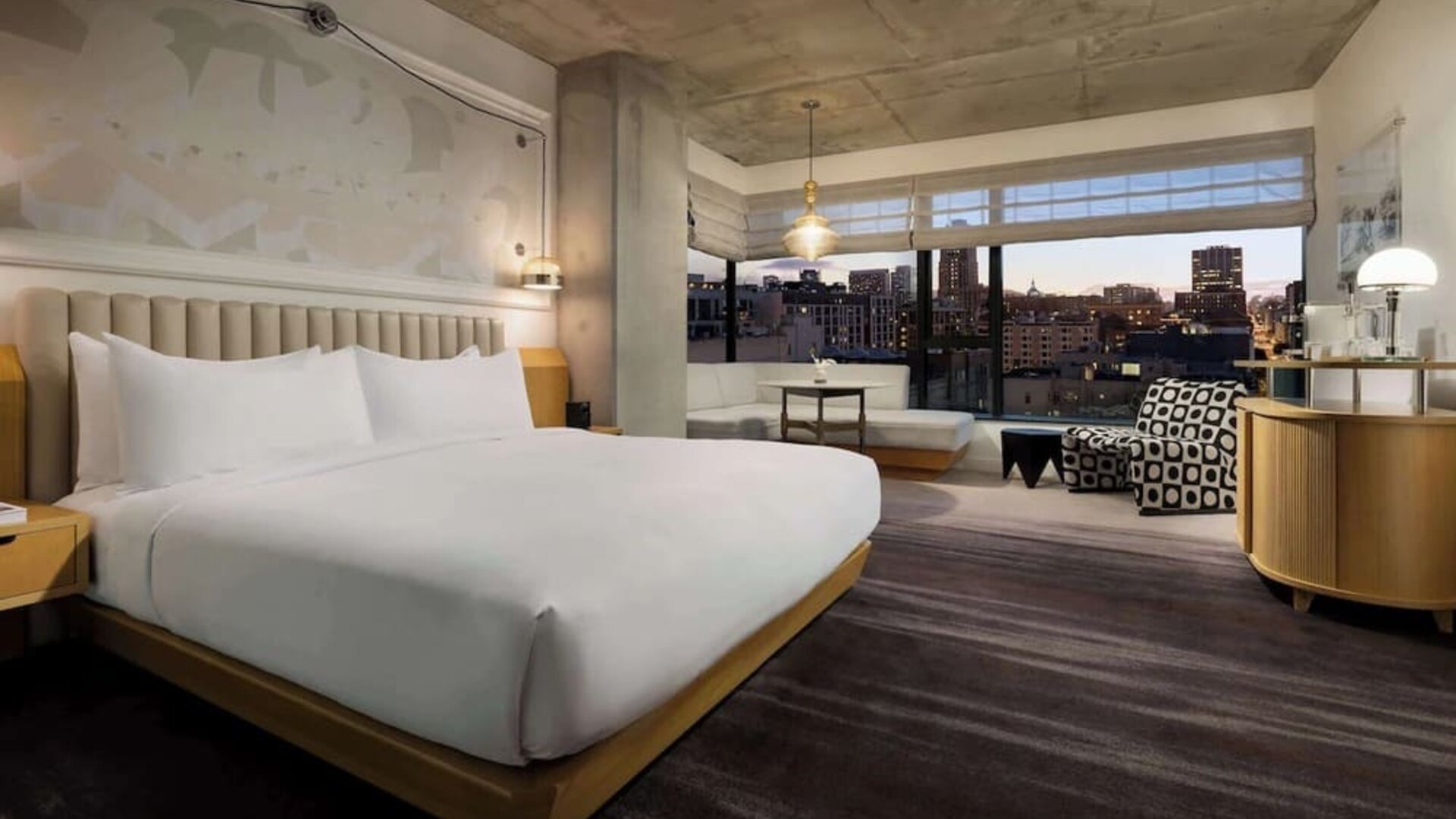 Comfortable king room with seating area, large windows, and warm interior tones at Timbri Hotel San Francisco, Curio Collection By Hilton.