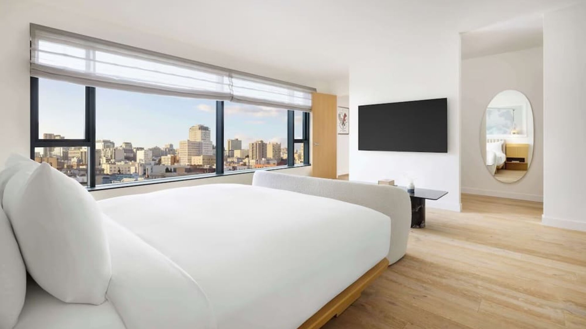 Bright modern room with large bed, floor-to-ceiling windows, and city views at Timbri Hotel San Francisco, Curio Collection By Hilton.