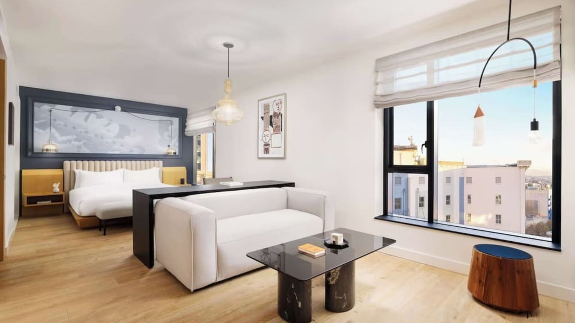 Bright suite with large bed, lounge seating, and expansive city views at Timbri Hotel San Francisco, Curio Collection By Hilton.