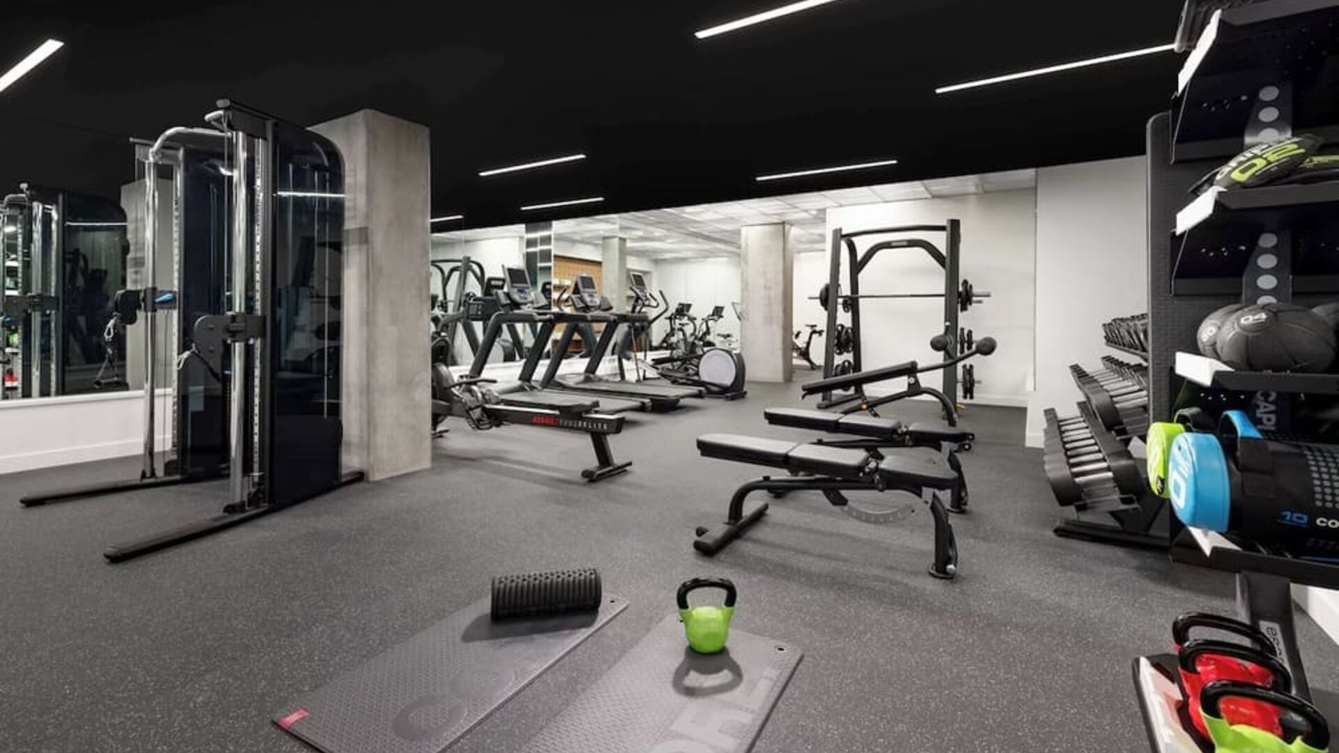 Fully equipped fitness center with weights, benches, and cardio machines at Timbri Hotel San Francisco, Curio Collection By Hilton.